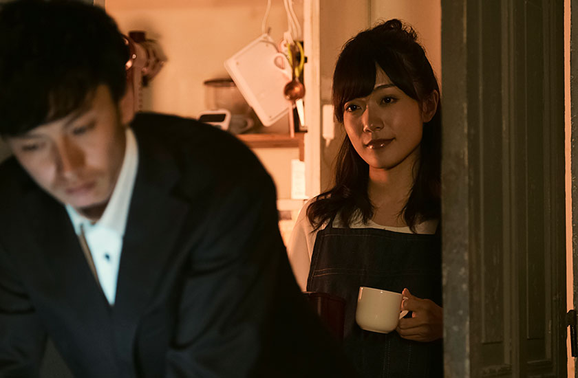 帰宅の遅い夫を見つめる既婚女性