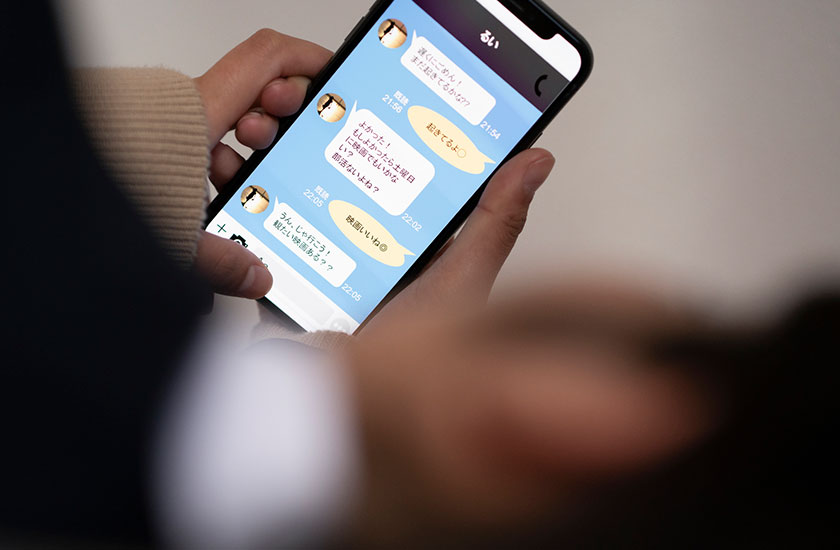 スマートフォンでSNSを見る女性