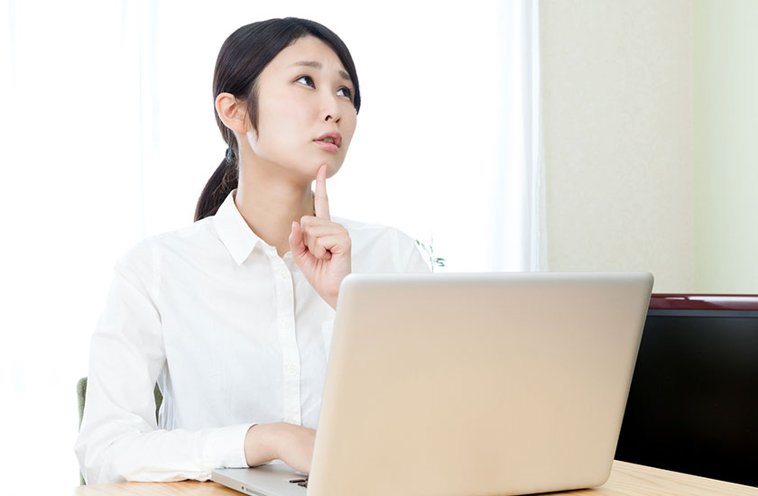ノートパソコンで探偵事務所を探す女性