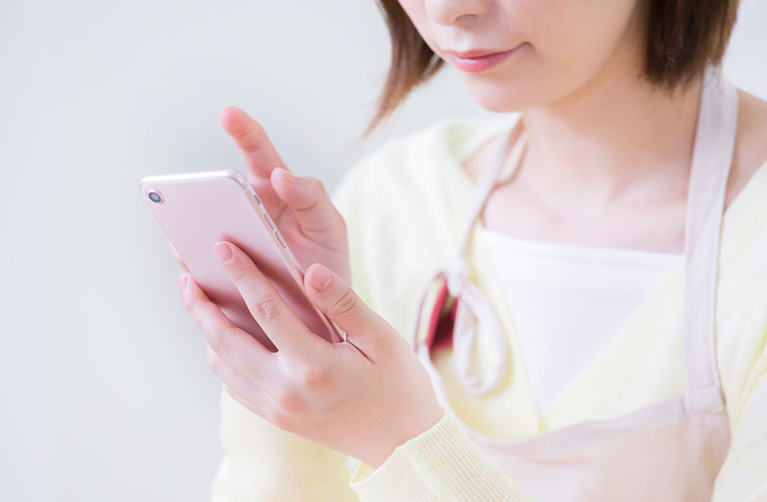 旅行中の夫に電話をかける妻