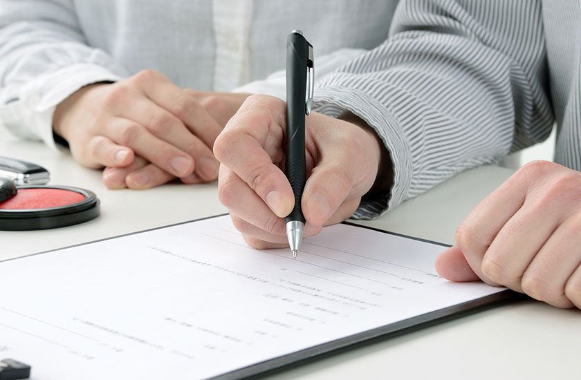 不倫の誓約書に記入する男性