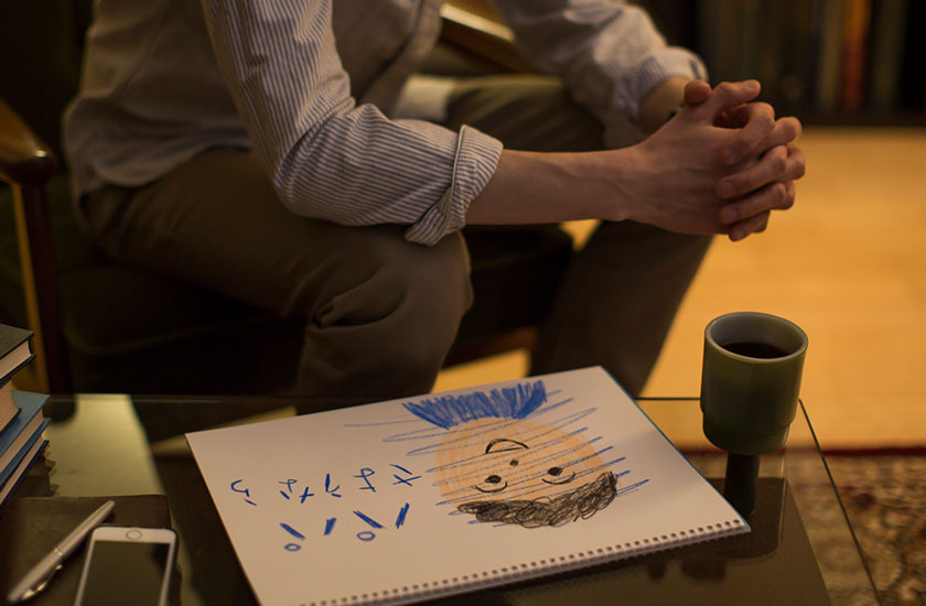 パパさよならと書かれた絵と落ち込む男性