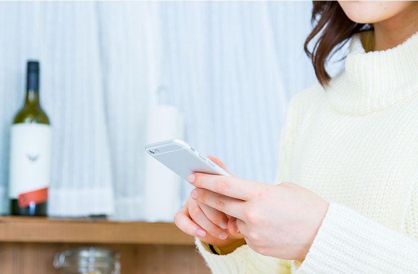 パートナーのスマホを操作する女性