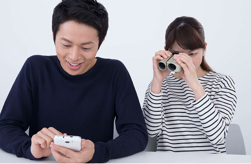 パートナーのスマホを覗き見する女性