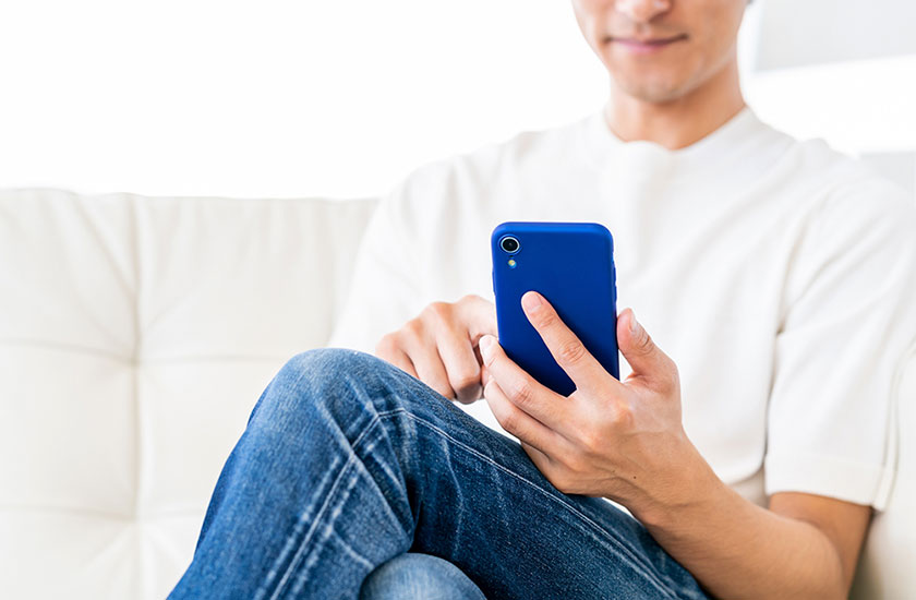 スマートフォンで浮気相手とのやり取りに夢中な既婚男性