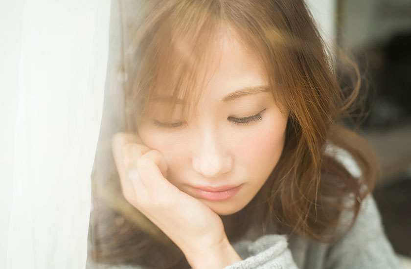 調査結果を受けて窓際で悩む女性