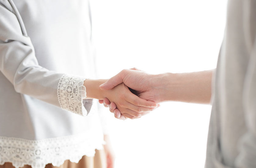 仲直りの握手をする夫婦