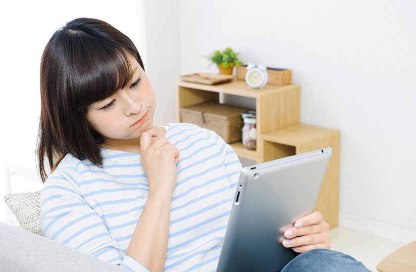 ホームページの探偵業届出番号を確認する女性