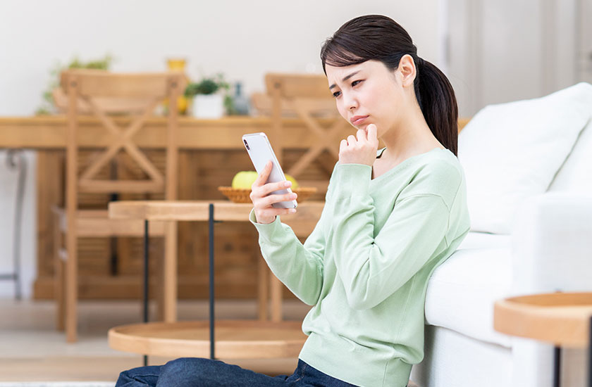 探偵社に寄せられるよくある質問を読む女性