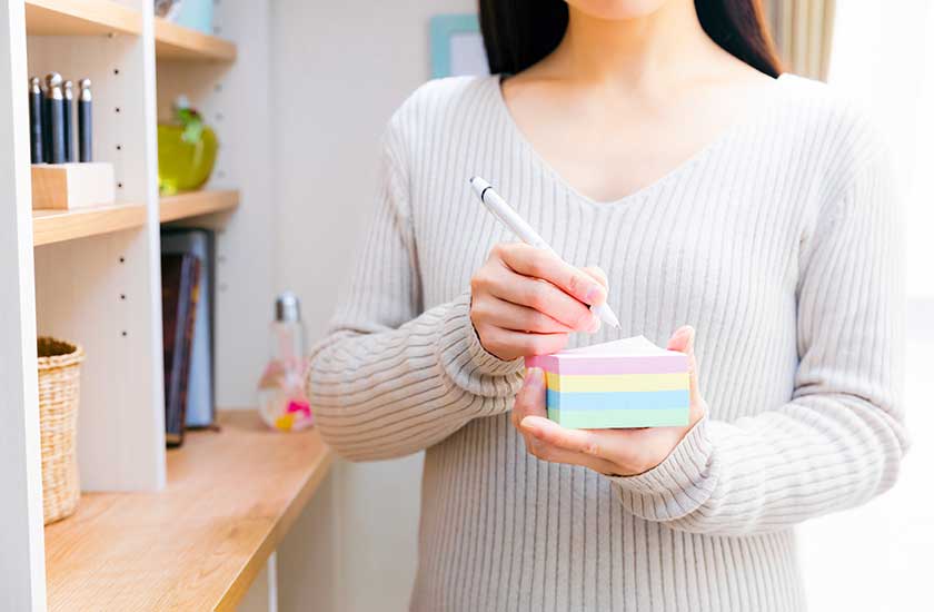 夫の様子を付箋にメモする妻