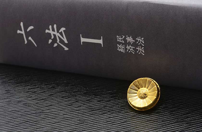 六法全書と弁護士バッジ