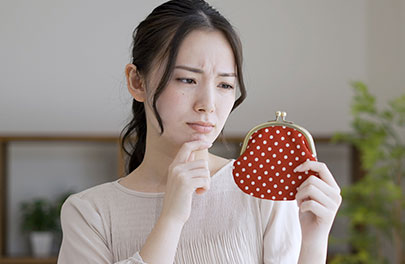 財布を持って悩んでいる女性